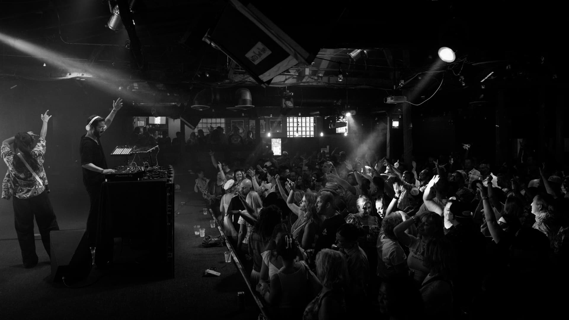 DJ performing for a packed club crowd