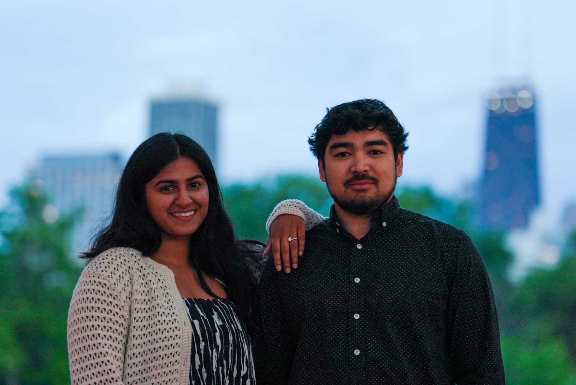 Engaged couple with the Chicago skyline behind them