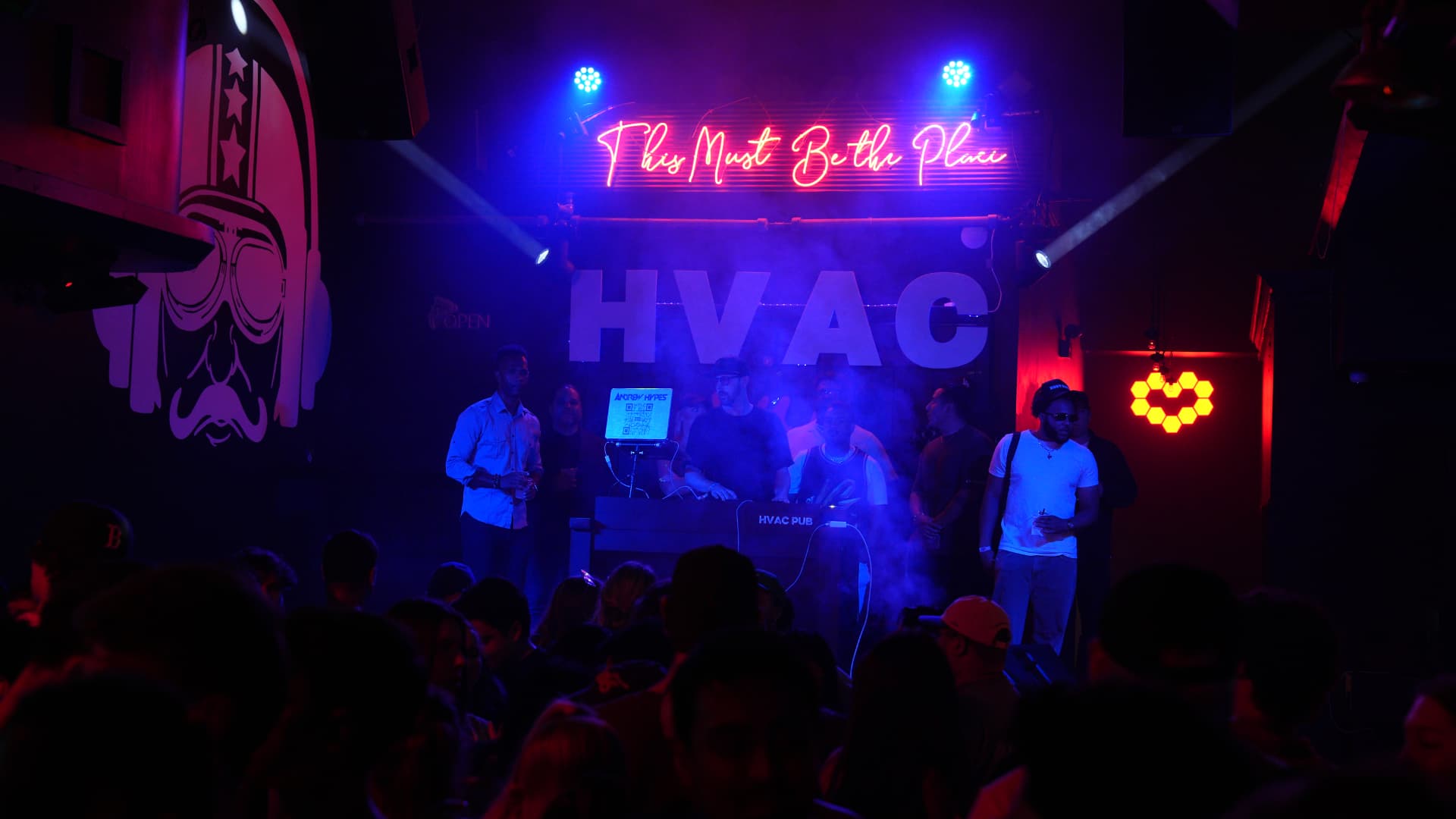 DJ booth glowing under neon signage